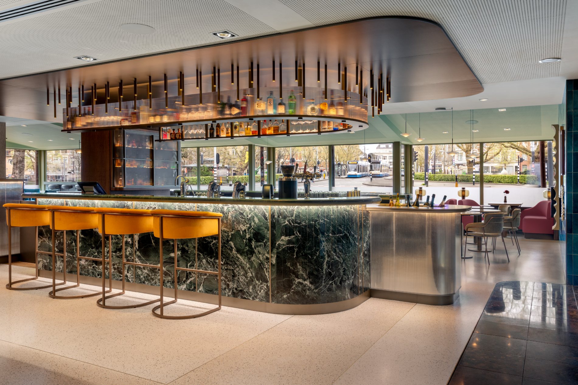 Maatwerk bar met groen marmer, messing en velours krukken — Marriott Amsterdam